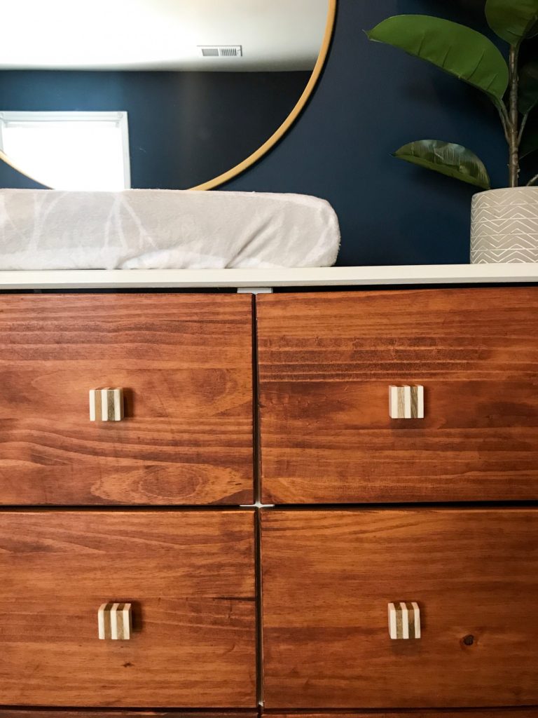 dark blue nursery, navy blue nursery, moody nursery, animal print, safari theme nursery, tribal nursery, lion rocker, tarva dresser, Ikea dresser hack, white crib, tiger print, elephant print, lion print, tribal rug, nursery books  