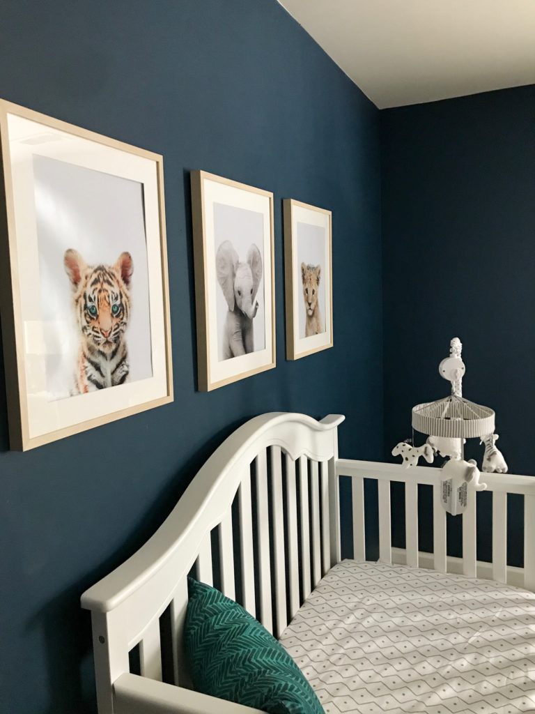 dark blue nursery, navy blue nursery, moody nursery, animal print, safari theme nursery, tribal nursery, lion rocker, tarva dresser, Ikea dresser hack, white crib, tiger print, elephant print, lion print, tribal rug, nursery books  