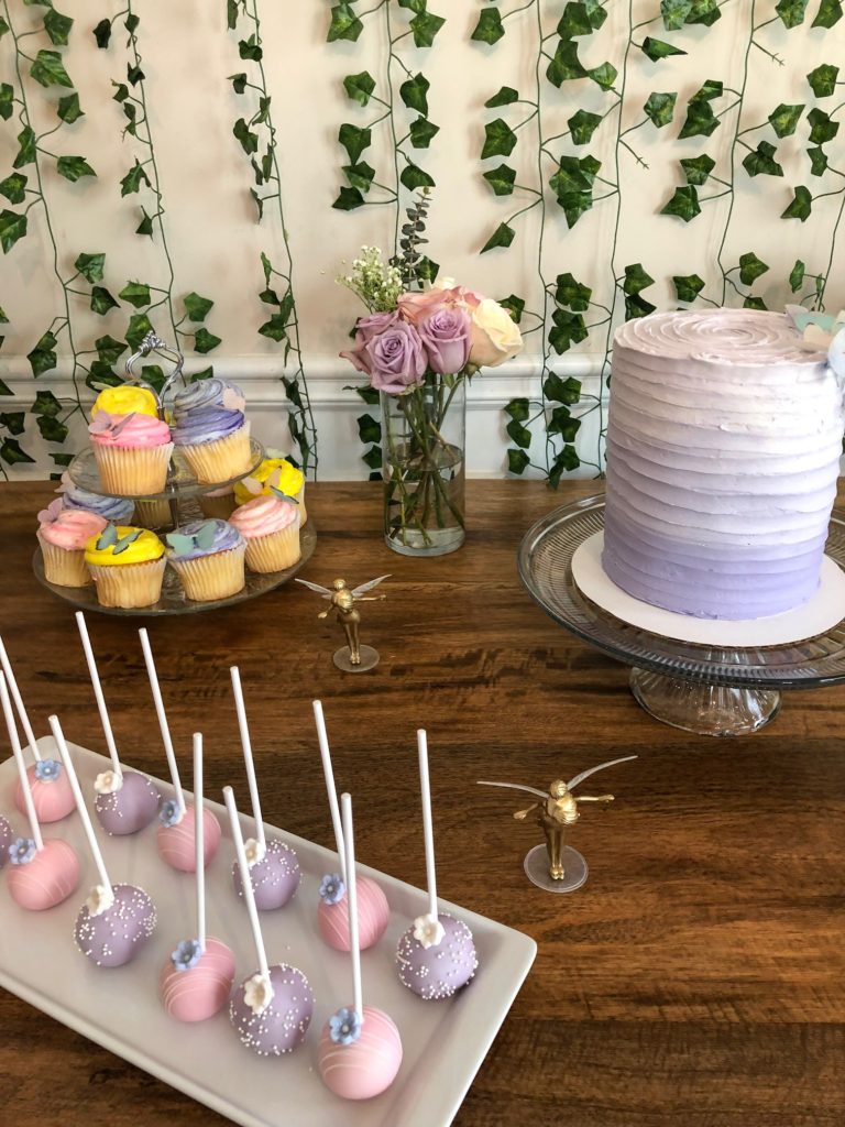 ombre cake, fairy party, fairy garden party, purple ombre cake, ivy backdrop, dessert table, edible butterflies, blush roses, mini fairy figurines, tea cups, tea cups with roses, cake pops, whimsical, third birthday party, fairy theme